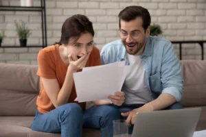 husband and wife rejoicing over good news they are reading Supporting your spouse's goals is good for your marriage.