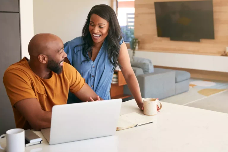 A couple sit at the computer together, in a discussion, asking questions. Asking the Right questions in marriage can strengthen your relationship.