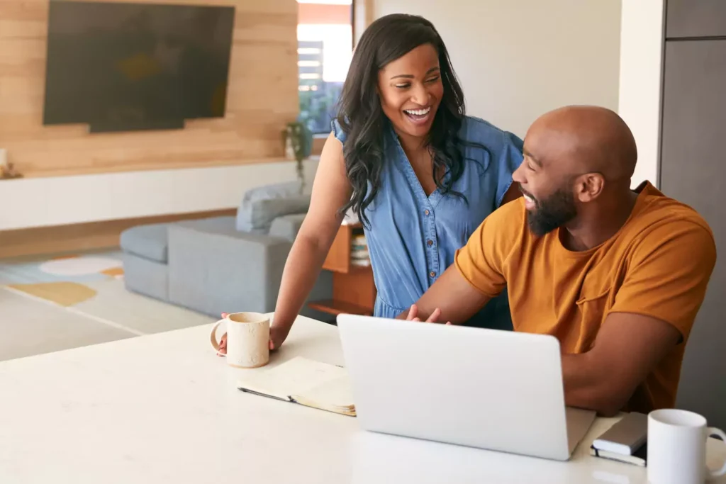 A couple sit at the computer together, in a discussion, asking questions. Asking the Right questions in marriage can strengthen your relationship.
