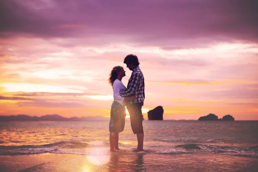 A couple embracing at sunset on the beach, symbolizing true love for your spouse through emotional connection and romantic devotion.