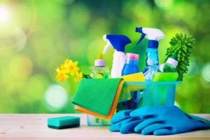 A vibrant collection of cleaning supplies, including spray bottles, sponges, rubber gloves, and microfiber cloths, symbolizing the concept of “spring cleaning for your marriage” against a fresh green background. The image conveys renewal and effort, much like maintaining a healthy relationship.