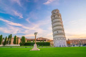 The Leaning Tower of Pisa, an iconic structure known for its tilt due to an unstable foundation, set against a scenic sunset sky. The image contrasts the importance of a solid foundation in architecture and life.