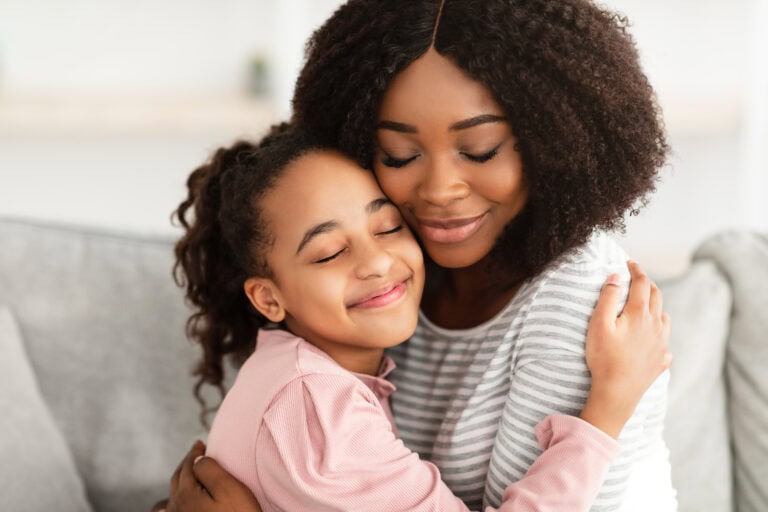 Closeup portrait of black mother and daughter hugging.