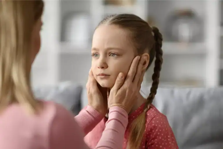 A mother gently holding a child’s shoulders during a calm conversation at home, illustrating a nurturing approach associated with biblical discipline and guidance.