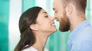 Close-up of a couple gently leaning in nose-to-nose, illustrating a relationship dynamic where a wife has higher sex drive than husband.