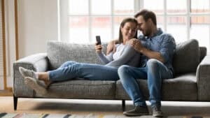 Is sex a need? A man and woman snuggle and laugh.