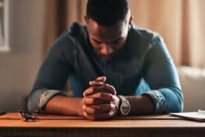 A man is praying for his wife.