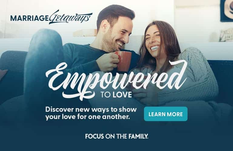 Couple laughing together on a couch - Marriage Getaways Empowered to Love