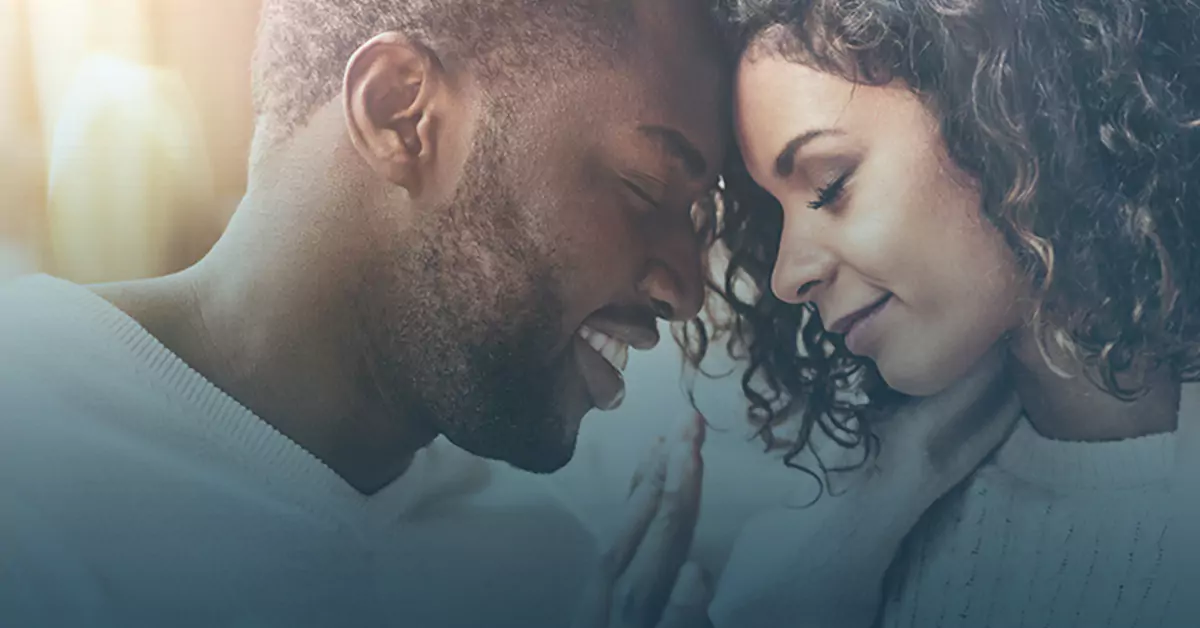 Intimate moment between couple with foreheads touching, soft lighting