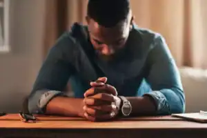 A man praying for his wife.