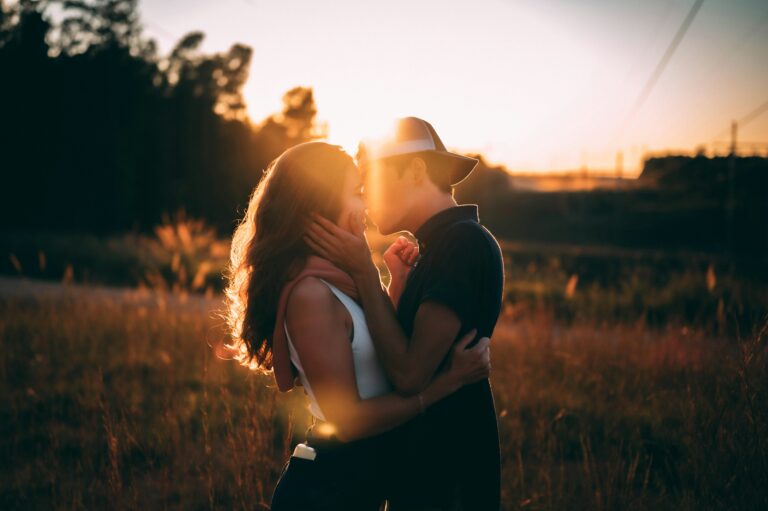 young couple kissing lit by evening sun