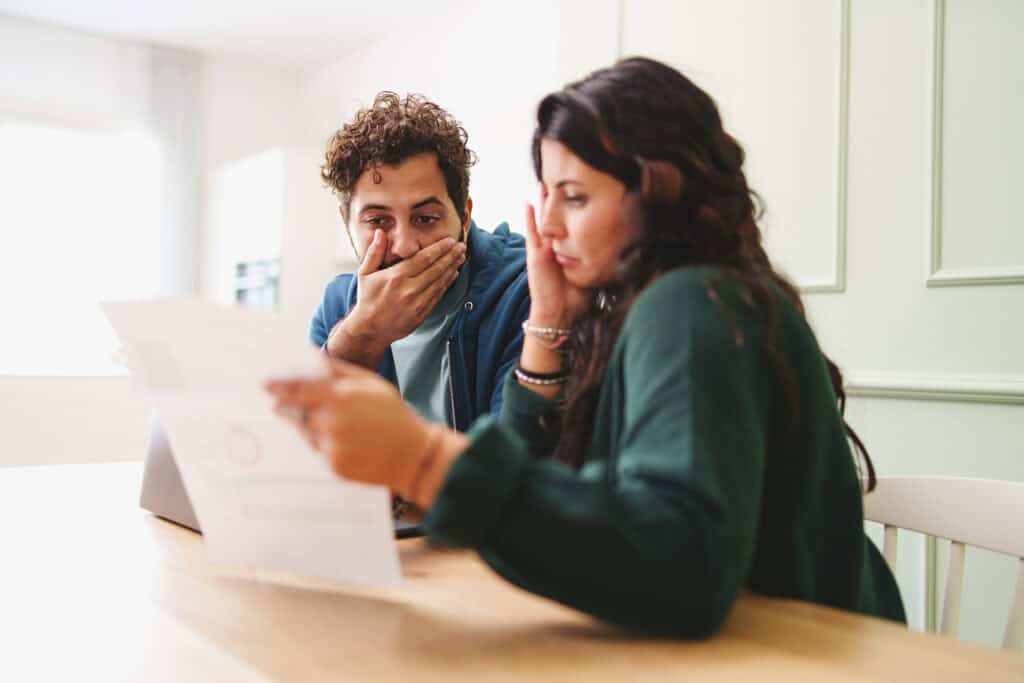 Fighting stress in marriage. A young married couple is worried looking at the electricity bill or the arrival of very expensive taxes