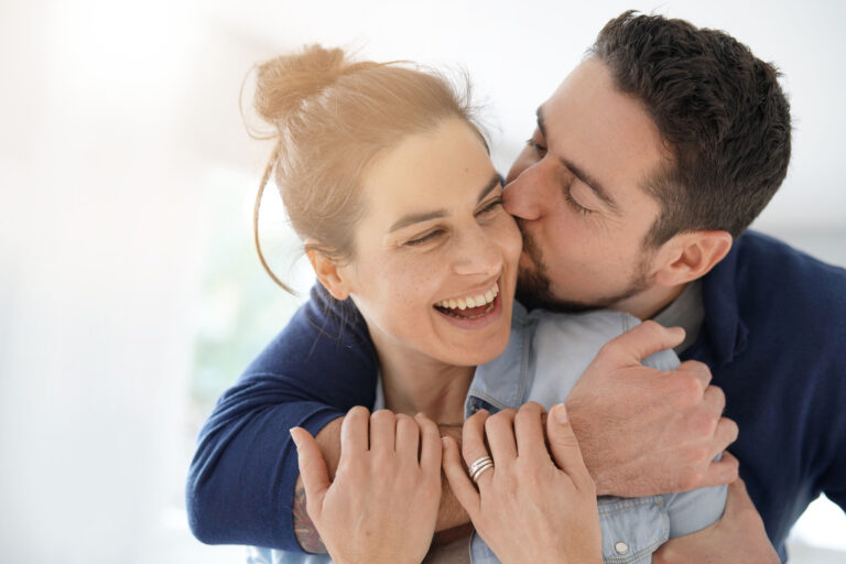How to Give Your Spouse a Gold-Medal Kind of Honor. A young, dark-haired man hugs his wife.