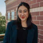 Sarah Rasmussen stands smiling next to the Focus on the Family building.
