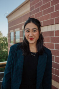 Sarah Rasmussen stands smiling next to the Focus on the Family building.