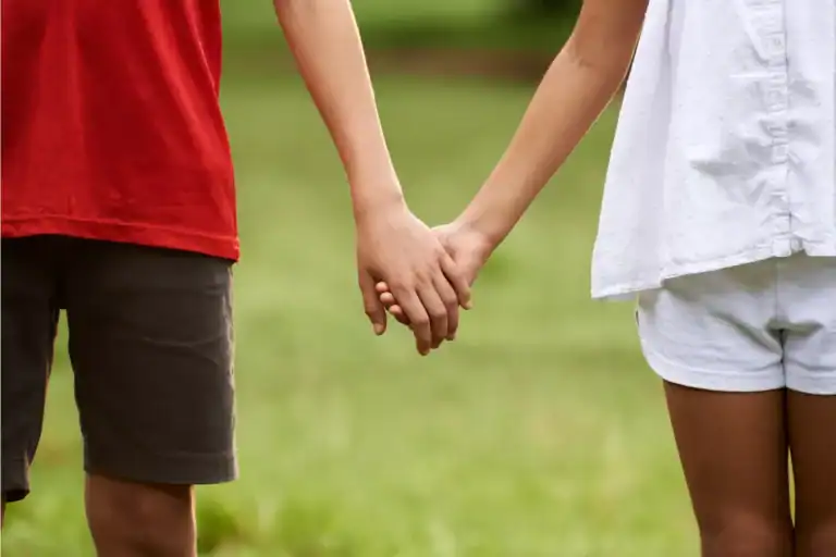 Children holding hands outdoors, illustrating emotions surrounding a child’s first crush.