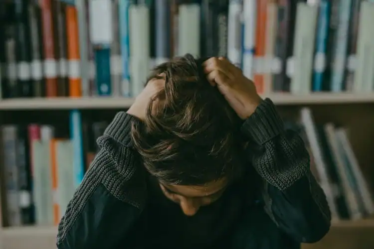 Boy in anguish sitting in a library