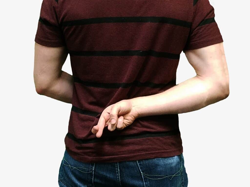 person holding crossed fingers behind their back