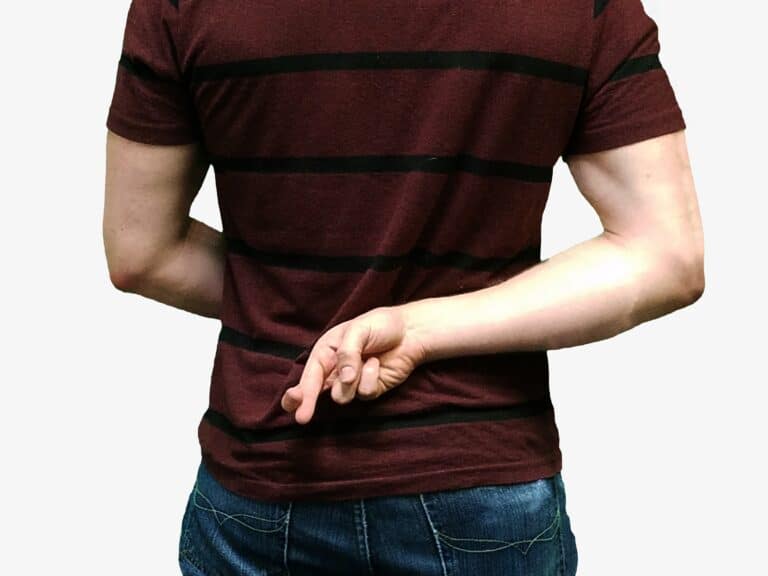 person holding crossed fingers behind their back
