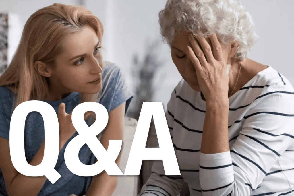 Mother and daughter sit on a couch, facing each other as one speaks with expressive hand gestures while the other listens with a hand resting near the face.