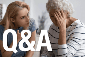 Mother and daughter sit on a couch, facing each other as one speaks with expressive hand gestures while the other listens with a hand resting near the face.