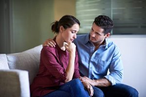 Shot of a husband comforting his wife in a hospital waiting room