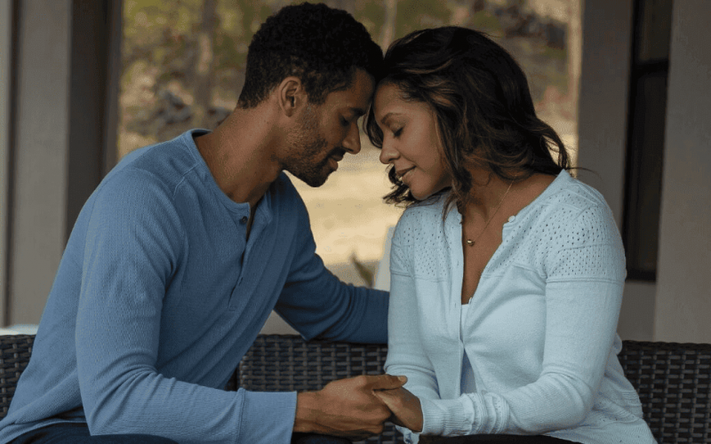 Young African-American couple sitting, facing each other, and being affectionate