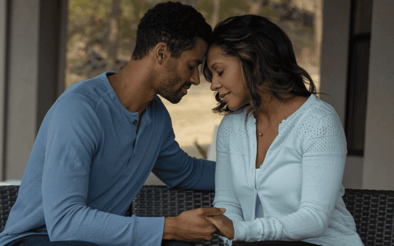 Young African-American couple sitting, facing each other, and being affectionate